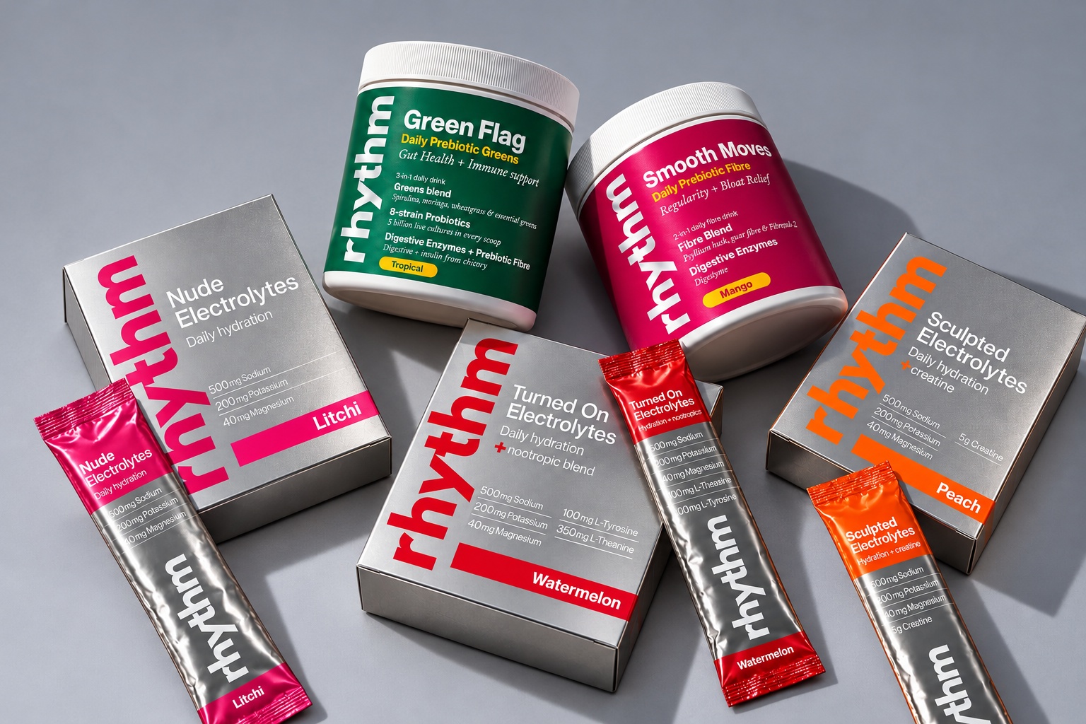 The full rhythm range: Nude, Turned On and Sculpted boxes and sachets with Green Flag and Smooth Moves tubs arranged on a matte grey background